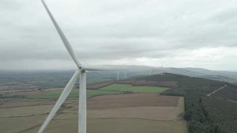 Acercándose-A-La-Turbina-Eólica-Giratoria-De-Pie-Sobre-La-Granja-En-Wexford,-Irlanda