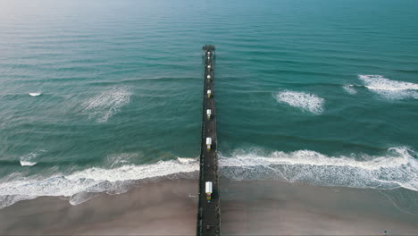 Epic-shot-of-pier-in-Atlantic-ocean,-bogue-inlet-pier-emerald-isle-nc