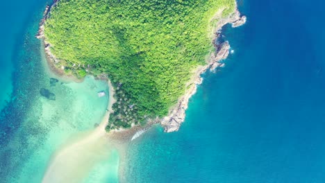 Aerial---uninhabited-island-with-palm-trees-in-the-aquamarine-calm-sea-water