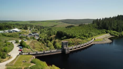 Alwen-Reservoir-dam-Conwy,-Wales---Aerial-drone-medium-distance-anti-clockwise-pan,-focus-on-dam-and-reveal-lake---June-23