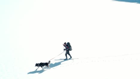 Mann-Beim-Skifahren-Mit-Seinem-Hund-Auf-Dem-Verschneiten-Feld-Tagsüber