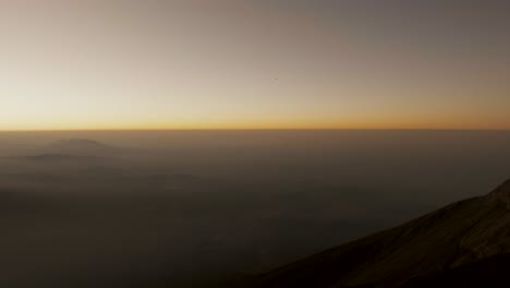 Hiker-Holding-Flags-Standing-On-The-Summit-Of-Acatenango-Volcano-During-Sunrise-In-Guatemala
