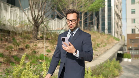 Businessman-using-phone-outdoors-on-the-way-to-office