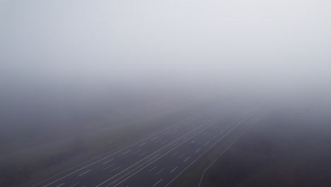 Aerial-sideways-flight-through-dense-clouds-revealing-German-highway-with-driving-cars-during-cloudy-day