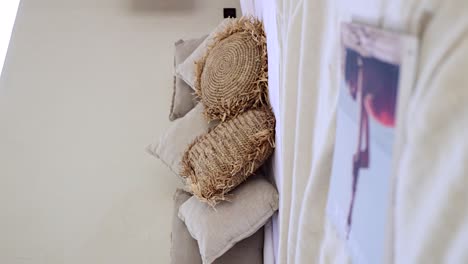 Vertical-boho-style-bedroom---Bohemian-rustic-throw-pillows-handmade-of-straw-paper-on-a-white-bed-cover---dolly-backwards