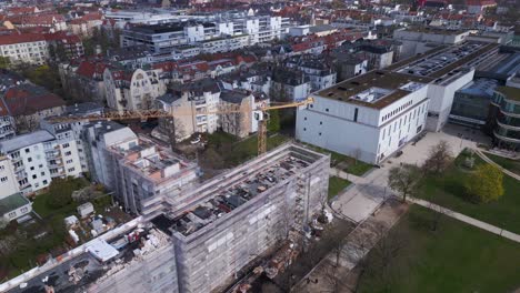 Unbelievable-aerial-top-view-flight-Berlin-City-Construction-work-on-house-with-crane