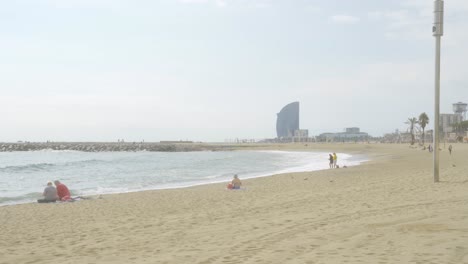 Wide-shot-Barceloneta-Beach-on-cloudy-day-in-Barcelona,-Spain