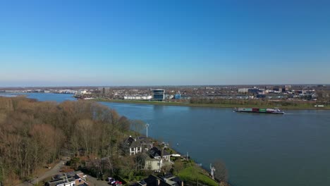 Wide-aerial-view-of-a-small-cargo-ship-navigating-through-the-canal-of-Zwijndrecht