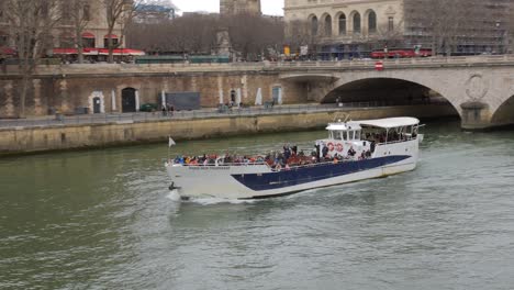 Tourists-Riding-A-Water-Bus-Over-The-Seine-River-In-The-City-Center-In-Paris,-France