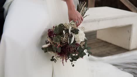Close-up-of-the-beautiful-colorful-bouquet-of-flowers-hooded-by-bride-in-the-church-chapel