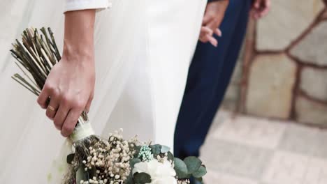Bride-With-White-Dress-Carrying-Flowers-Bouquet-Holding-Her-Groom's-Hand-At-Wedding-Day