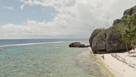 Tourists-walking-along-Fronton-exotic-tropical-Caribbean-beach,-Las-Galeras-in-Dominican-Republic