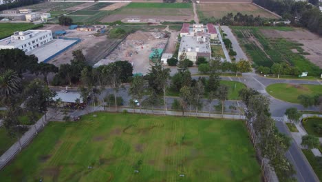 Drohne-Fliegt-Und-Neigt-Die-Gimbal-Kamera-Langsam-Nach-Oben,-Um-Die-Landwirtschaftlichen-Felder-Der-Nationalen-Agraruniversität-Von-Peru-Zu-Zeigen