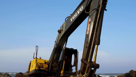 Abandoned-Yellow-Digger-on-Rocky-Beach-Thailand