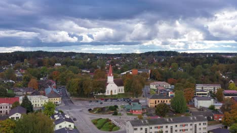 Iconic-small-European-town-with-autumn-colors-and-dark-clouds,-aerial-view