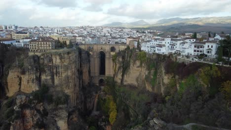 Magical-city-of-Ronda-on-side-of-steep-rocky-cliff,-aerial-drone-view