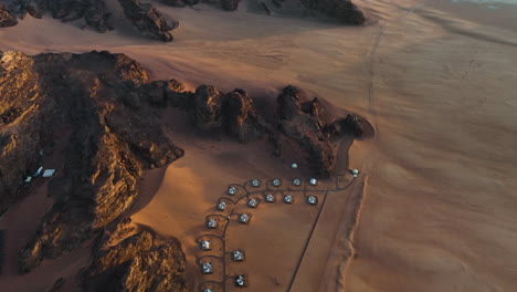 Drone-shot-of-a-remote,-deluxe-camp-in-middle-wilderness-of-Wadi-Rum,-Jordan