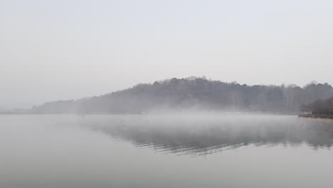 Misty-quiet-lake,-peacefully-and-tranquil-atmosphere,-natural-lake-landscape-environment-concept
