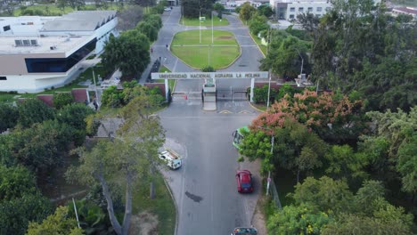 Drone-Volando-Sobre-La-Entrada-De-La-Universidad-Nacional-Agraria,-En-Español,-Universidad-Nacional-Agraria