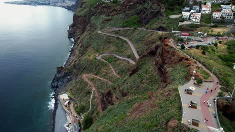 Aerial-view-over-winding-zigzag-steps-down-to-Ponta-do-Garajau-coastal-shore,-Madeira,-Portugal