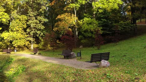 Zauberhafte-Bänke-Im-Lebhaften-Park-Mit-Herbstfarben,-Blick-Auf-Die-Umlaufbahn