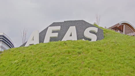Wide-pan-past-AFAS-sign-on-a-hill-in-Leusden
