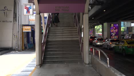 Escena-De-Gente-Caminando-Y-Bajando-Las-Escaleras-De-La-Estación-De-Tren-Aéreo-Bts-Sala-Daeng,-Un-Bullicioso-Centro-Comercial-Y-De-Transporte-En-Silom,-Bangkok,-Tailandia