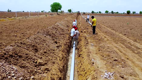 Indischer-Bauer-Und-Arbeiter,-Die-Auf-Dem-Großen-Baggerland-An-Den-Wasserleitungsanschlüssen-Arbeiten,-Folgeaufnahme-Eines-Arbeiters,-Der-Auf-Dem-Bauernhof-Arbeitet