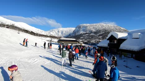 Long-waiting-line-to-enter-ski-lift-as-skiers-arrive-in-bottom-of-hill-in-Myrkdalen-Norway---Handheld