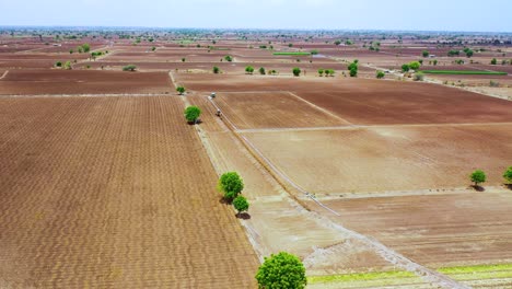 Aerial-wide-angle-shot-of-working-excavation-machine-at-farm-for-water-system-underground-pipeline