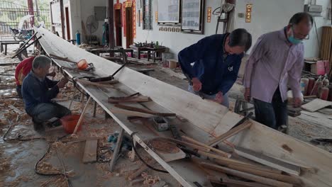 Chinesische-Handwerker-Montieren-Den-Rumpf-Eines-Drachenbootes