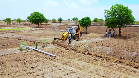 Landscape-view-of-earthmoving-machine-working-at-land-in-India,-heavy-duty-excavation-machine-at-Indian-agricultural-land