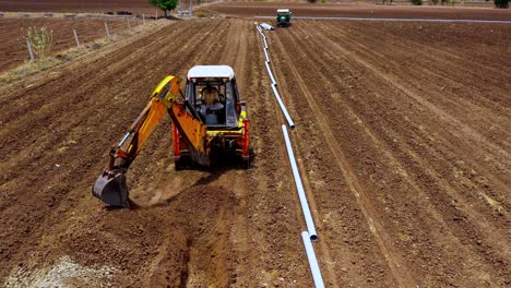 dig-read-soil-by-excavation-aerial-top-angle-view,-digging-an-agricultural-soil-for-water-solution