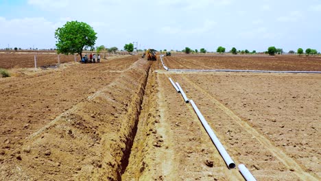 zoom-in-shoot-of-working-excavation-machine-at-farm-for-water-system-underground-pipeline
