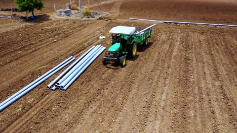 Water-pipeline-unloading-at-agricultural-farm-and-tracker-also,-water-pipeline-system-for-irrigation