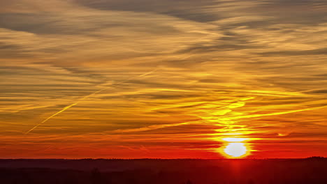 Ein-Wunderschöner-Orangefarbener-Sonnenaufgang-Unter-Einer-Kumuluswolkendecke-über-Einer-Ebene