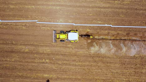 aerial-top-angle-view-of-excavation-digging-straight-line-at-agricultural-land-for-water-solution-at-summer
