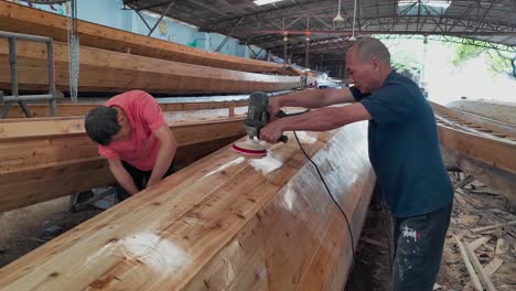 Artesanos-Puliendo-El-Casco-Del-Barco-Dragón-En-La-Fábrica-De-Barcos