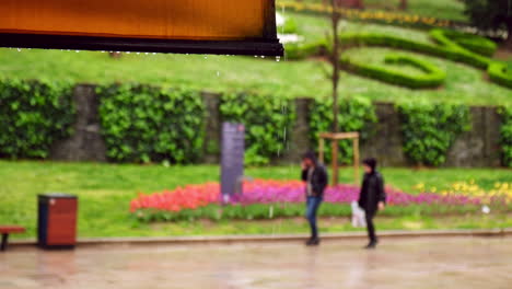 The-couple-is-walking-under-the-rain-in-The-Park-Of-Gulhane-in-Istanbul-in-slow-motion