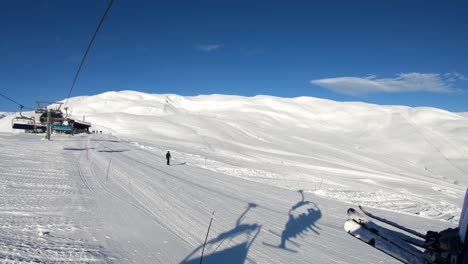 Llegando-A-La-Cima-Del-Remonte-Myrkdalsekspressen-En-Myrkdalen,-Noruega,-Visto-Desde-El-Remonte:-Clima-Soleado-Y-Cielo-Azul-Con-Gente-Esquiando-Debajo