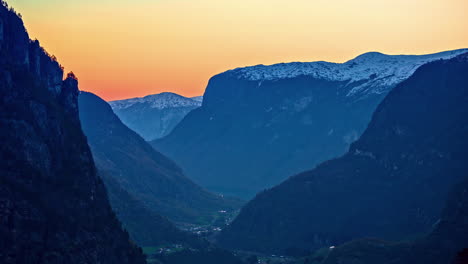Hermosa-Puesta-De-Sol-Naranja-Sobre-Un-Valle-Con-Altas-Montañas