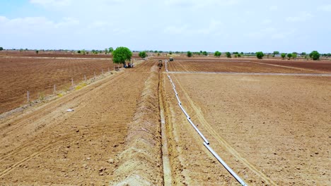 Aerial-ground-shot-of-working-excavation-machine-at-farm-for-water-system-underground-pipeline