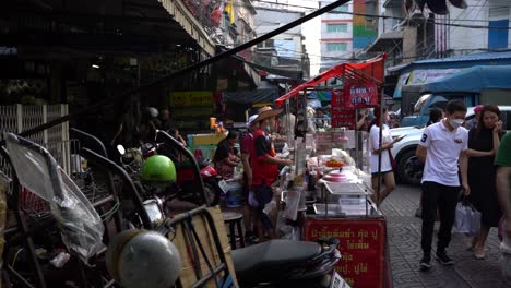 Vista-De-Gente-Caminando-Y-Vendedores-Ambulantes-De-Comida-Esperando-Clientes-En-Chinatown,-Bangkok,-Tailandia