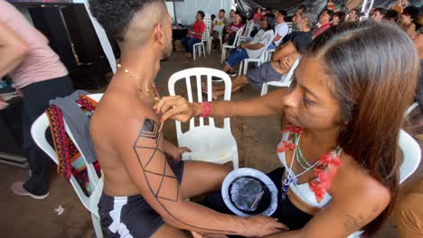 Una-Joven-De-La-Región-Amazónica-Pinta-A-Un-Joven-Con-Dibujos-Tradicionales