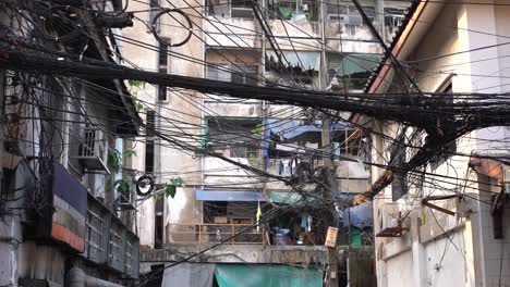 Messy-and-disorganized-electrical-wiring-cables-in-Chinatown-,-Bangkok,-Thailand