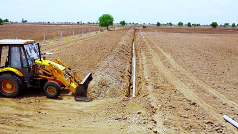 Siga-La-Toma-De-Una-Máquina-De-Movimiento-De-Tierras-Que-Cubre-Una-Tubería-De-Agua-Subterránea-Con-Tierra-En-La-India