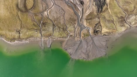 Drohne-Rotiert-über-Einem-Atemberaubenden-Wassergrünen-See-Mit-Geologischer-Erdsteinformation
