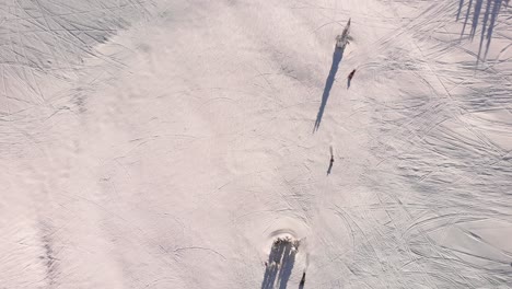Drone-overhead-shot-of-snowmobiles-making-tracks-on-the-snow
