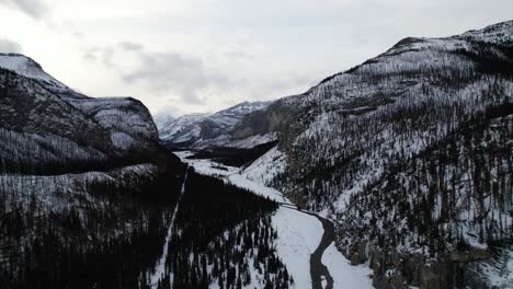 Drone-flying-towards-a-snow-covered-fairytale-mountainous-valley-in-Canada