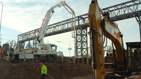 Construction-foreman-walking-leisurely-between-heavy-duty-vehicles